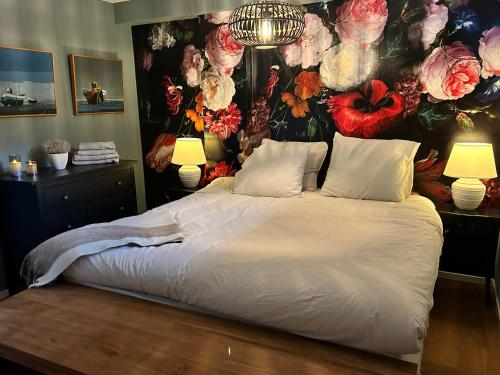 ein Schlafzimmer mit einem großen Bett mit Blumenwand in der Unterkunft Villa Park in Bennebroek