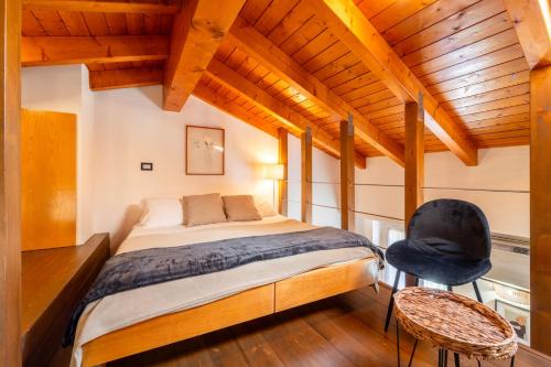 a bedroom with a bed and a chair at Casa Roncati by Wonderful Italy in Bellagio