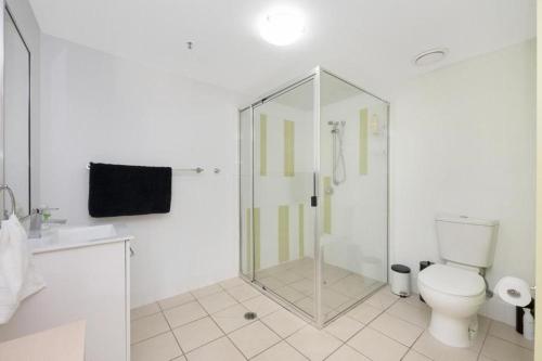 a white bathroom with a shower and a toilet at Apartment on Palmer in Townsville