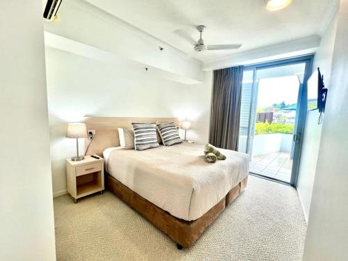 a bedroom with a bed and a large window at Apartment on Palmer in Townsville