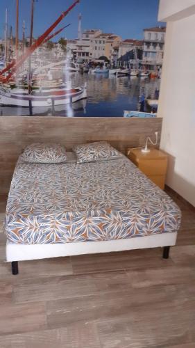 un lit dans une chambre avec une grande fenêtre dans l'établissement LE PATIOT 2, à Six-Fours-les-Plages