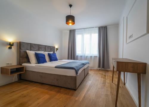 une chambre avec un grand lit avec des oreillers bleus dans l'établissement BelVie Residence, à Vienne