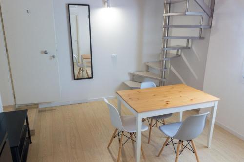 a dining room with a table and chairs and a spiral staircase at Agriturismo Ca' Manzato in Passarella