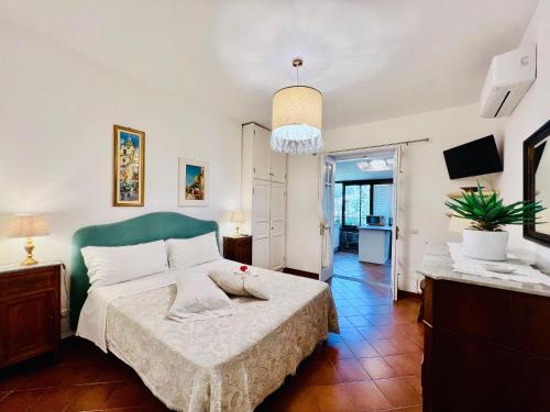 Schlafzimmer mit einem großen Bett mit einem grünen Kopfteil in der Unterkunft YourHome - Maison Iolanda Positano in Positano