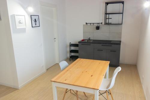 een keuken met een houten tafel en witte stoelen bij Agriturismo Ca' Manzato in Passarella