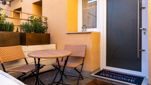 un patio con 2 sillas, una mesa y una puerta en Della Grazia 1-2 A en Bolonia