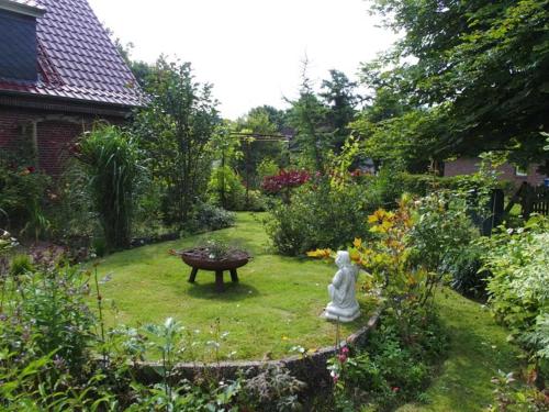 ogród z posągiem na środku podwórza w obiekcie Ferienhaus Magnolia w mieście Wittmund
