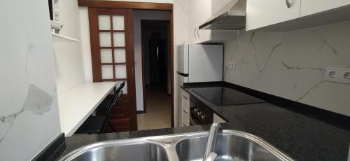 cocina con fregadero y nevera en Apartment - 2 Bedrooms - 0137, en Cangas de Morrazo