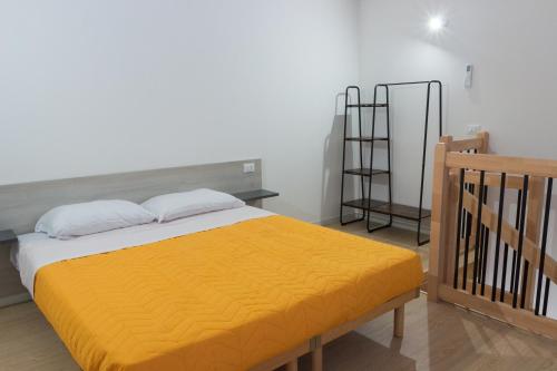 a bedroom with a bed with an orange blanket at Agriturismo Ca' Manzato in Passarella
