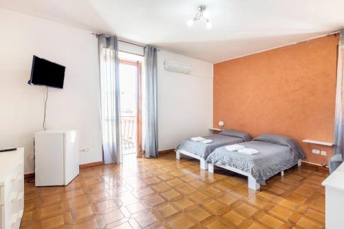 um quarto com 2 camas e uma televisão de ecrã plano em Angolo d'Epoca con Bagno Privato nel centro Storico em Vibo Valentia