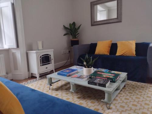 a living room with a blue couch and a coffee table at The Mews Cottage in Penzance