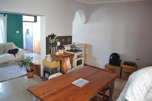 a kitchen with a wooden table and a stove at Obz House in Cape Town