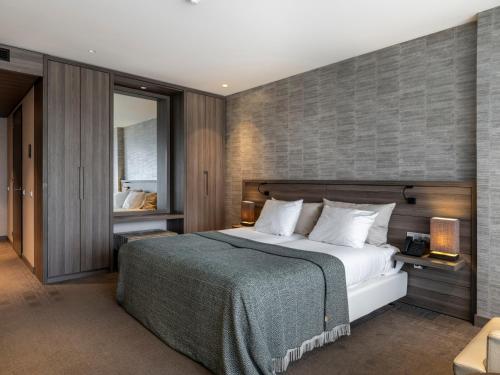 een slaapkamer met een groot bed en een bakstenen muur bij Van Der Valk Hotel Zwolle in Zwolle