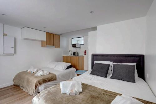 2 Betten in einem Zimmer mit weißen Wänden in der Unterkunft 135 Suite Franck - Charmant Studio à Paris in Paris