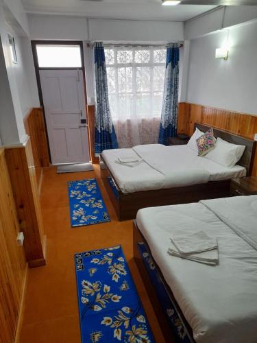 a room with two beds and blue mats in it at Yalung Homestay in Darjeeling