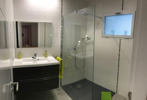 bagno con doccia in vetro e lavandino di Llevantpicafort a Can Picafort