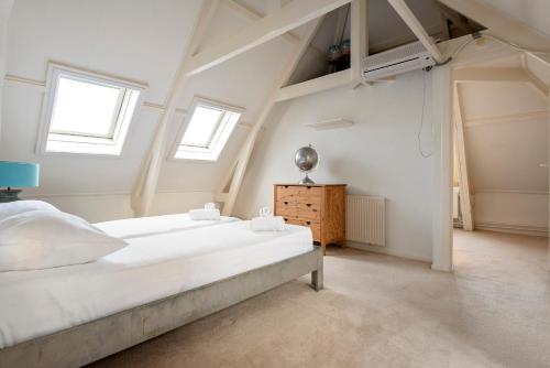 een slaapkamer met een groot bed en 2 ramen bij Zandvoort Zenith - Beautiful Apartment in Zandvoort