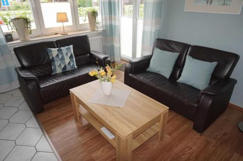 a living room with two leather couches and a coffee table at Ferienhaus Ortgies in Carolinensiel