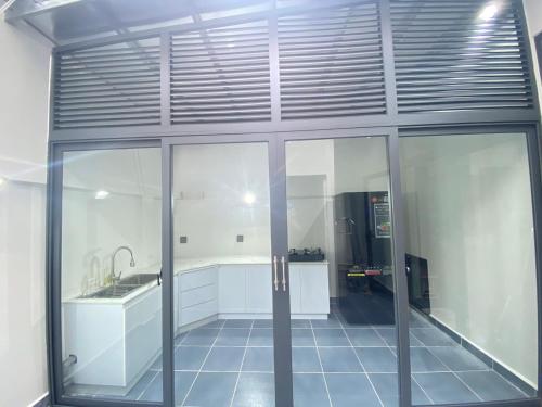 uma cozinha com armários brancos e uma grande parede de vidro em UY LONG Homestay & Coffee em Duong Dong