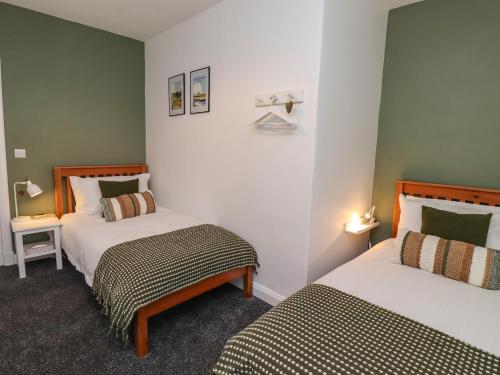 2 camas en una habitación con paredes verdes en 2A Front Street en Alnwick