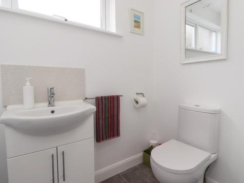 a white bathroom with a toilet and a sink at 2A Front Street in Alnwick