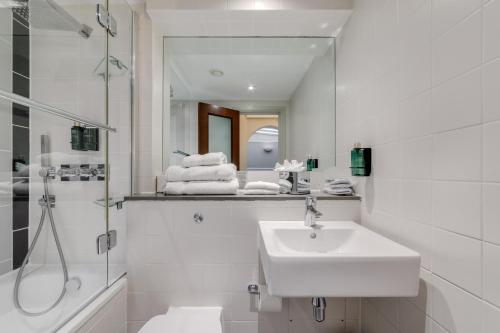 y baño blanco con lavabo y ducha. en Best Western Mornington Hotel Hyde Park en Londres