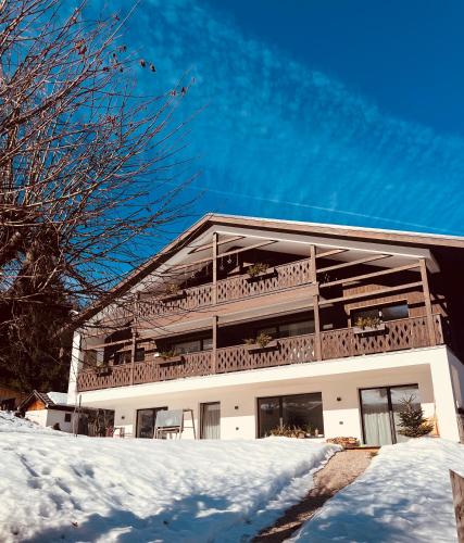 a large white building with a balcony in the snow at Ciasa Valiares in San Vigilio Di Marebbe