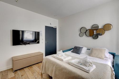 een slaapkamer met een bed en een flatscreen-tv bij 152 Suite Sylvie - Superb apartment in Paris in Parijs