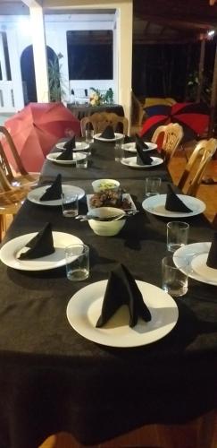 une table noire avec des plaques blanches et des serviettes noires dans l'établissement Lions Villa & Resort, à Deniyaya