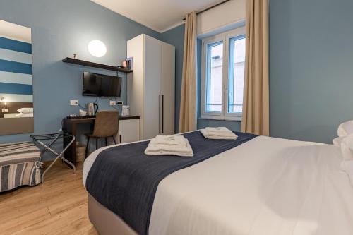um quarto com uma cama, uma secretária e uma televisão em La Loggia de' Banchi em La Spezia