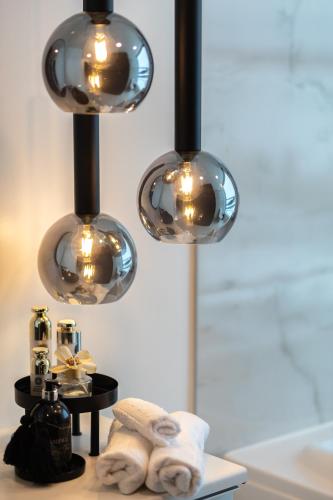 a bathroom with three lights hanging over a sink at Tallinn Tartumnt 84a in Tallinn