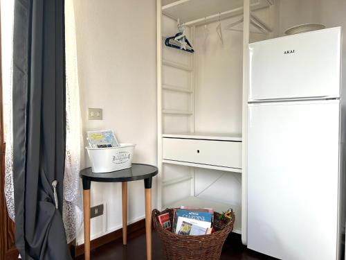 a small kitchen with a refrigerator and a table at In campagna in Besozzo