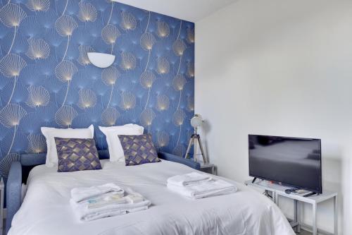 um quarto com uma cama com uma parede azul em 807 Suite Cosy - Superb Apartment em Bagnolet