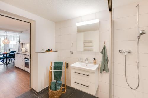 a bathroom with a sink and a shower at Alpen Bijou mit Bergkulisse & Liebe zum Detail in Adelboden