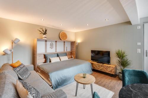 una camera da letto con un letto, un divano e una TV di Alpen Bijou mit Bergkulisse & Liebe zum Detail ad Adelboden