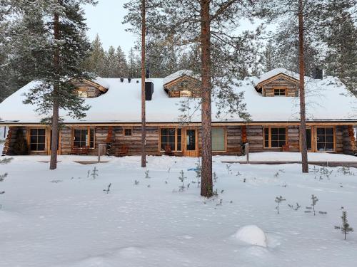 Cabaña de madera con nieve en el techo en Holiday Apartments Aurinkosuomu en Kemijärvi