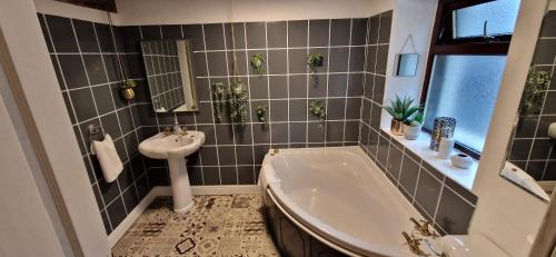 uma casa de banho com uma banheira e um lavatório em Beautiful Cosy Townhouse 3 Double beds 2 Bathroom FREE PARKING em Kendal