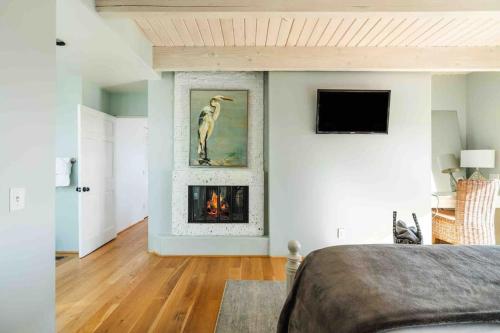 a bedroom with a fireplace and a tv on the wall at Summer Beach House in Summerland