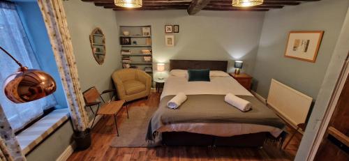 um quarto com uma cama e uma cadeira em Beautiful Cosy Townhouse 3 Double beds 2 Bathroom FREE PARKING em Kendal