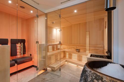 a bathroom with a tub and a glass wall at Chalet Marmotta CULM - Luxus Chalet Ski-In Ski-Out in Sankt Anton am Arlberg