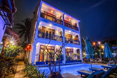 a building with a swimming pool at night at Trendy Life Villa in Hoi An