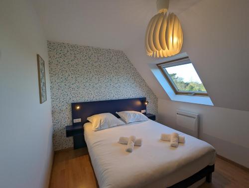 1 dormitorio con 1 cama con 2 zapatillas en TY FLOSQUE - Jolie maison familiale proche plage, en Ploudalmézeau