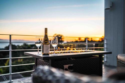 a bottle of wine and two glasses on a table at Summer Beach House in Summerland