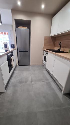 une cuisine avec un réfrigérateur et une machine à laver dans l'établissement Face mer et plages appartement avec terrasse., à Nice