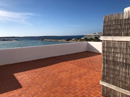 a brick patio with the ocean in the background at Apartamentos Sabina Playa in La Savina