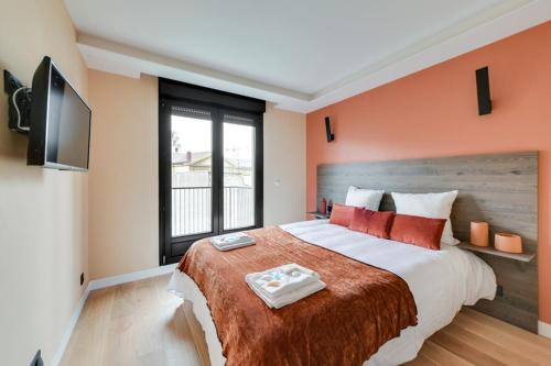 a bedroom with a large bed with orange walls at 182 Suite Two - Superb apartment in Paris in Paris