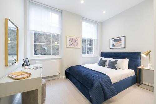 1 dormitorio con 1 cama, escritorio y ventanas en Urban Chic – Drury en Londres