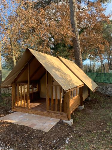 Villaggio Camping Bosco Selva في ألبيروبيلو: كابينة خشبية كبيرة مع سقف مزفلت