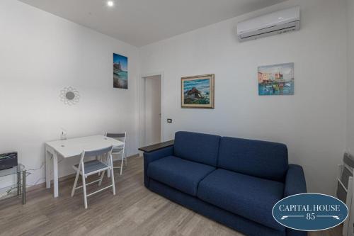 a living room with a blue couch and a table at Capital house 85 in La Spezia