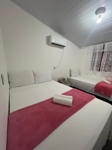 a room with two beds with red and white sheets at Casa Recanto - Villa Uryah in Caraíva